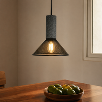 Industrial grey textured stone and black mesh cone pendant light hanging above a wooden dining table for contemporary kitchen styling.