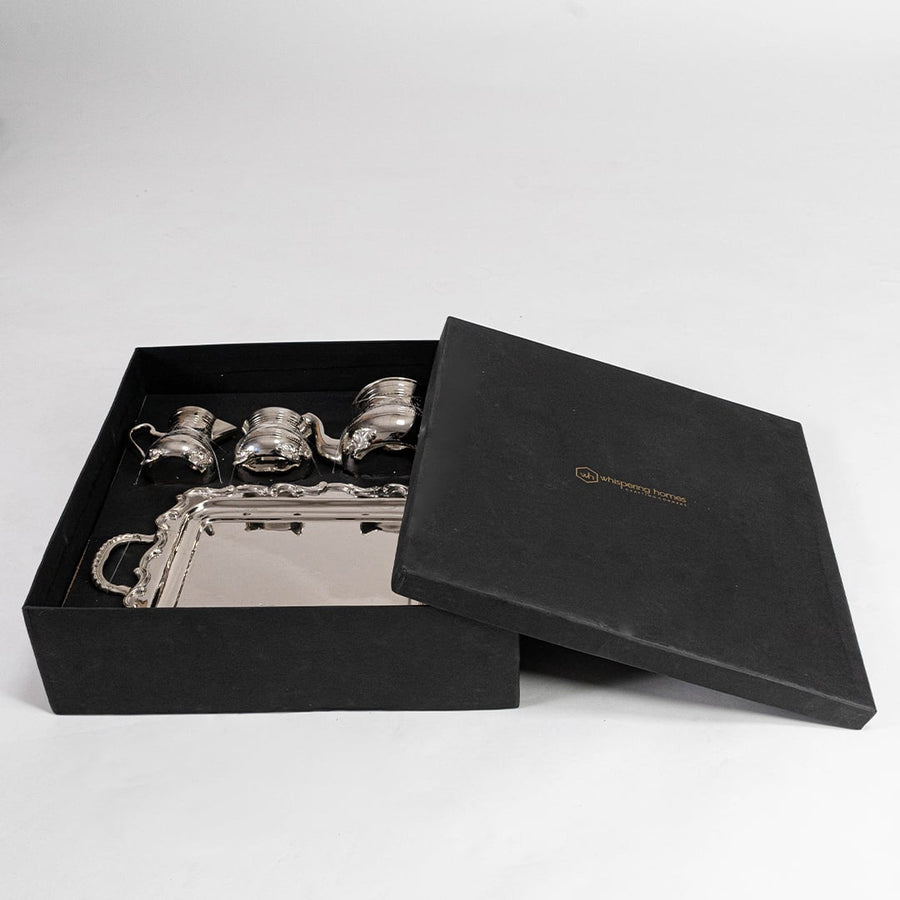 Complete silver tea set displayed on white background highlighting intricate engravings and polished metallic shine.