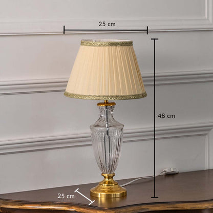Glass table lamp with gold base and beige pleated shade displayed on white background featuring height 48 cm and width 25 cm for precise measurements.