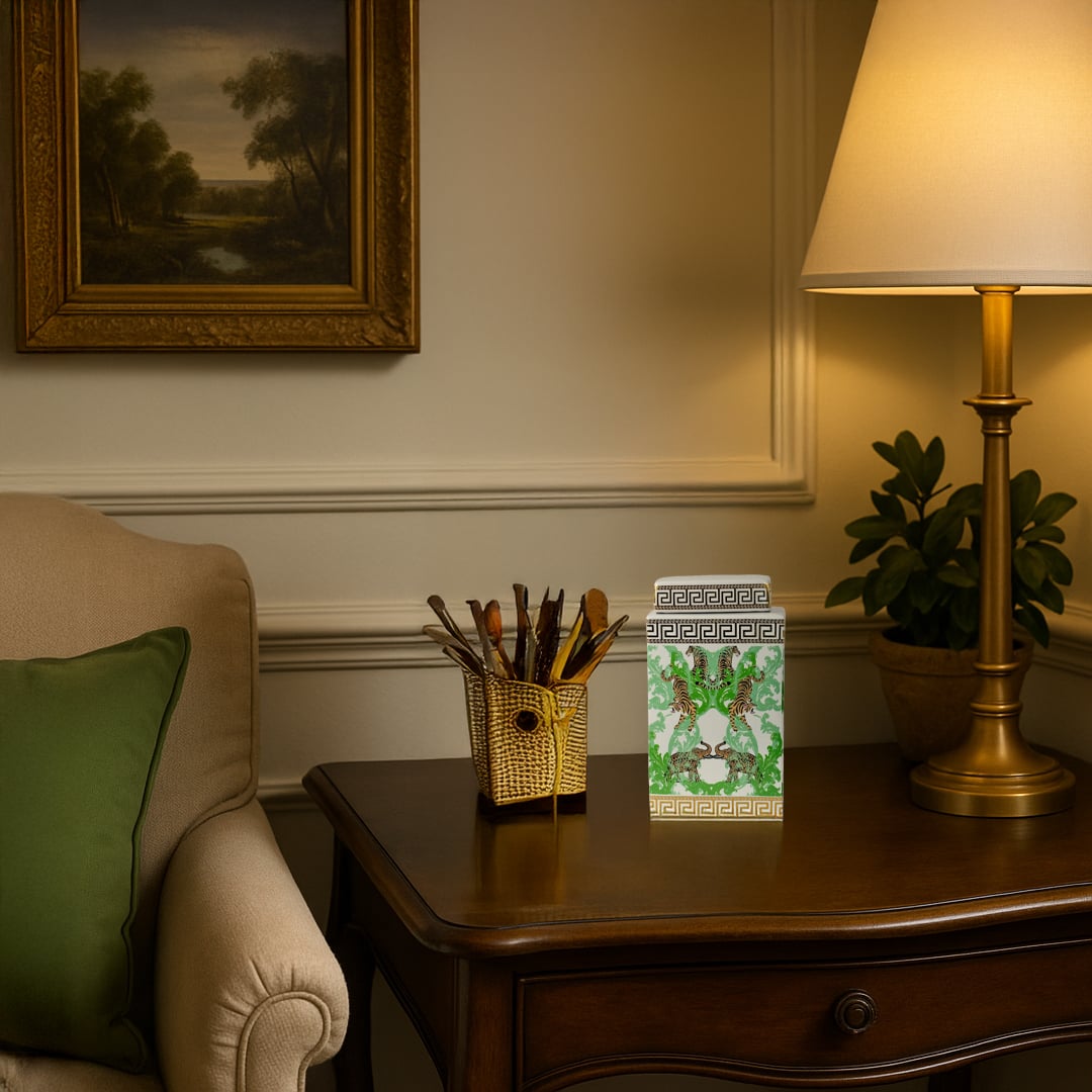 White ceramic jar with gold and green tiger design adding a luxurious accent to a classic wooden side table.