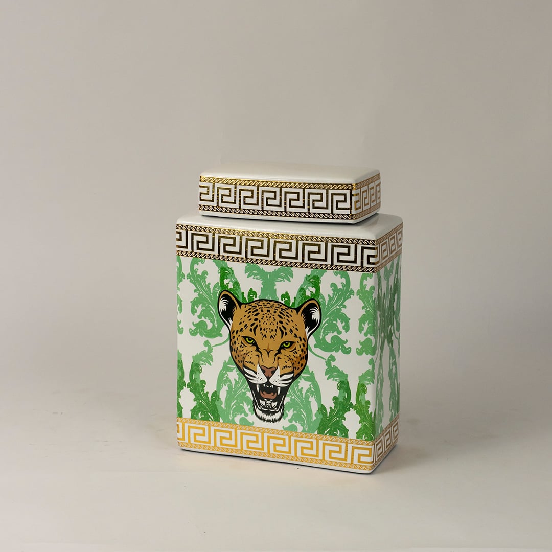 Side angle view of white ceramic jar showing gold-trimmed edges and detailed hand-painted leopard artwork.