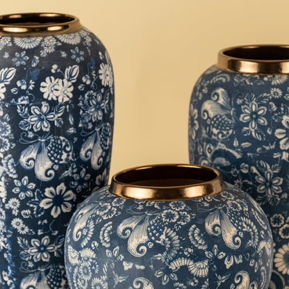 Artistic blue ceramic vase featuring hand painted white floral motifs with sleek golden rim detailing.