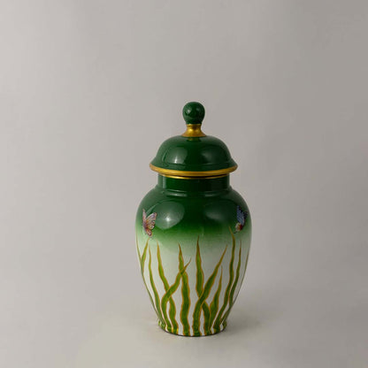 Green ceramic jar with glossy finish and lid placed on white surface against neutral background enhancing vibrant decorative home decor aesthetic.