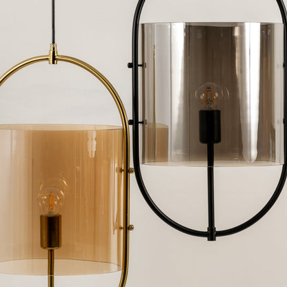 Close-up of modern pendant hanging lights with oval metal frames and tinted glass shades in amber and chrome finishes for any space.
