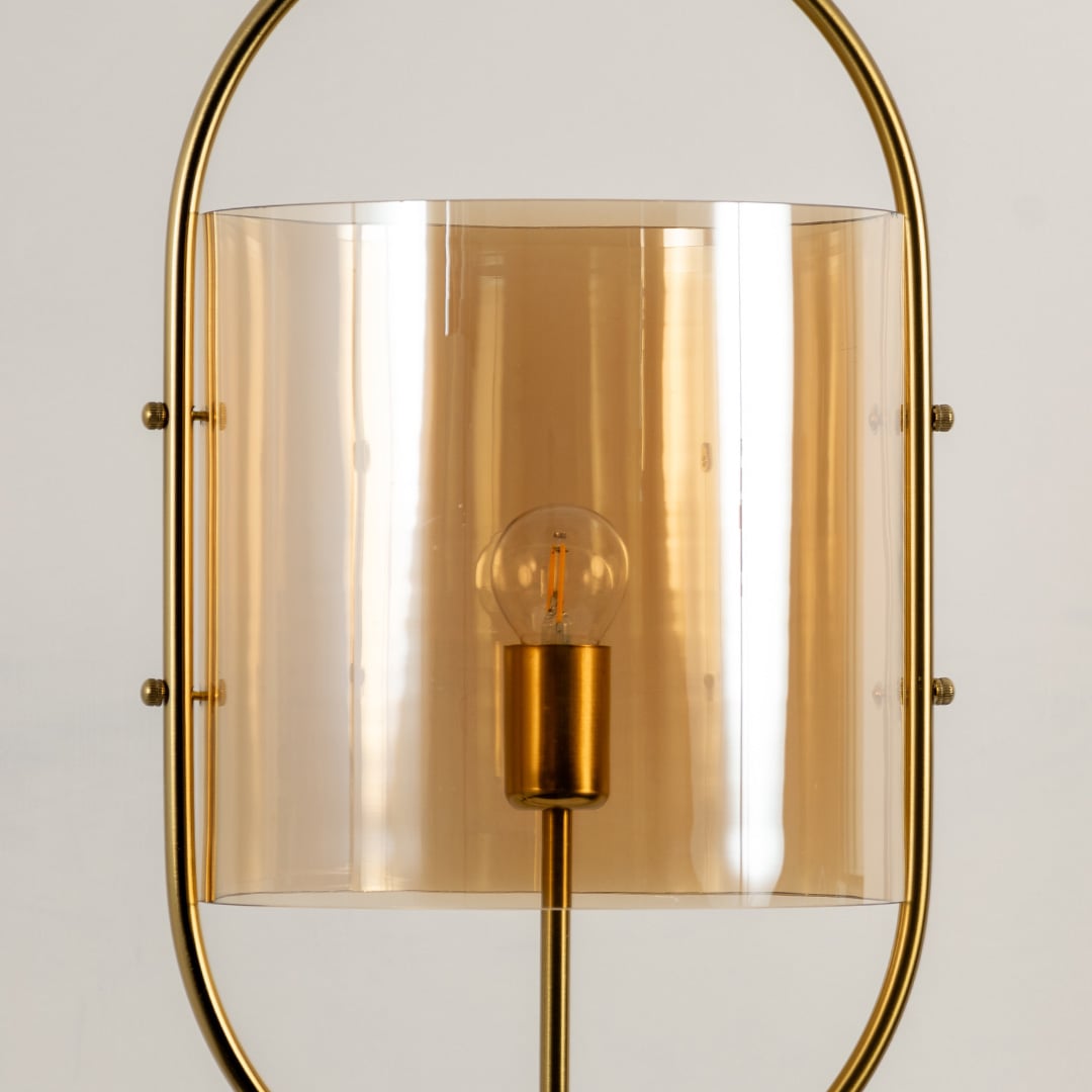 Closeup highlighting the refined golden metal finish and curved amber glass shade with visible warm bulb detailing.