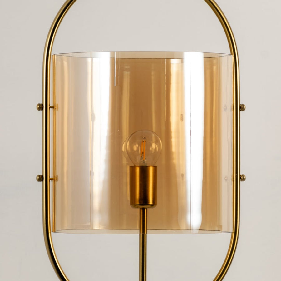 Closeup highlighting the refined golden metal finish and curved amber glass shade with visible warm bulb detailing.