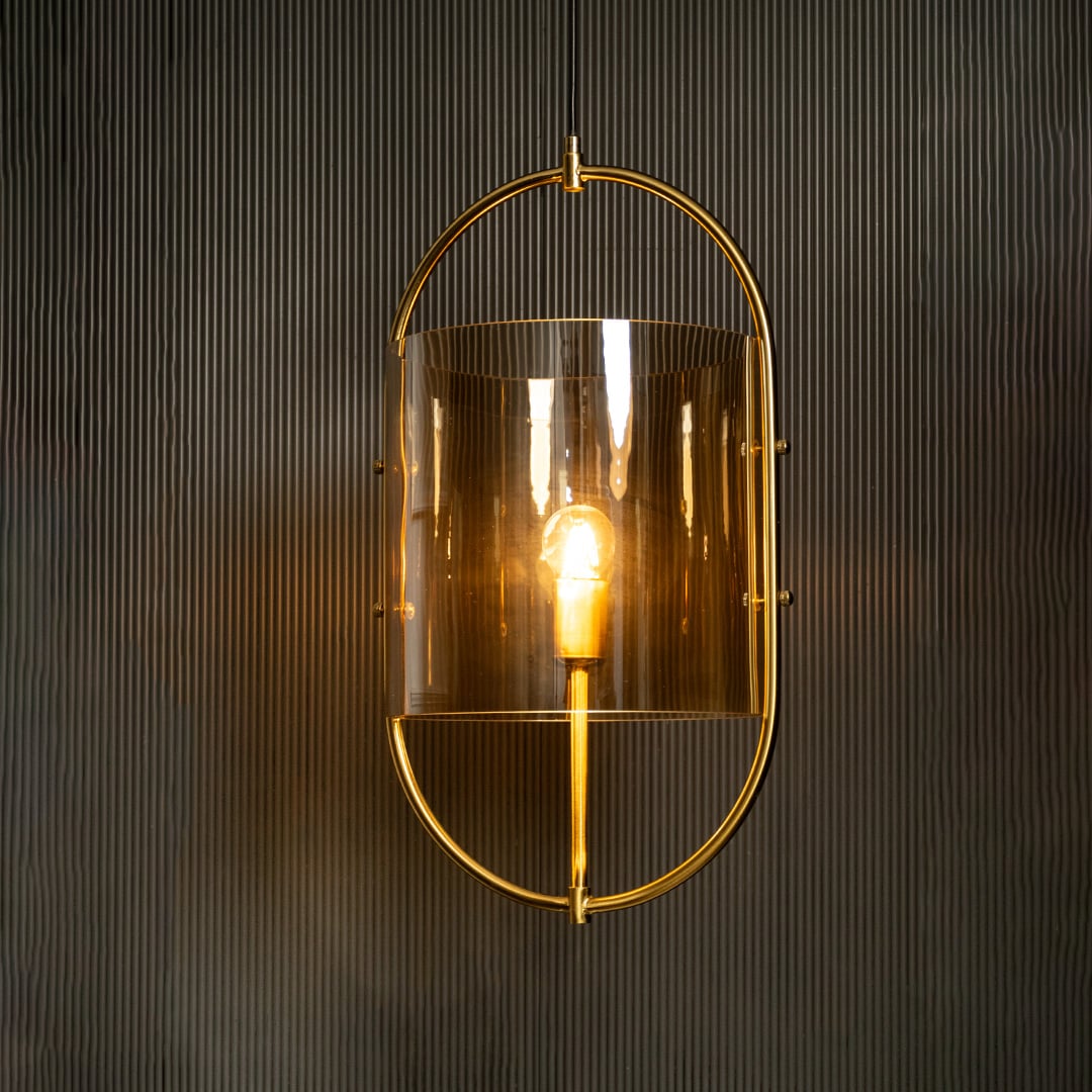 Illuminated pendant showcasing golden metal accents and glowing amber glass creating a striking contrast against a dark backdrop.