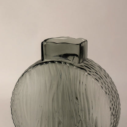Closeup of smoky gray round glass vase highlighting its intricate wavy pattern and elegant matte glass finish.