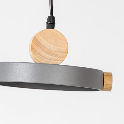 Closeup of wood and metal pendant light with circular round design and black cord for modern home interior lighting.