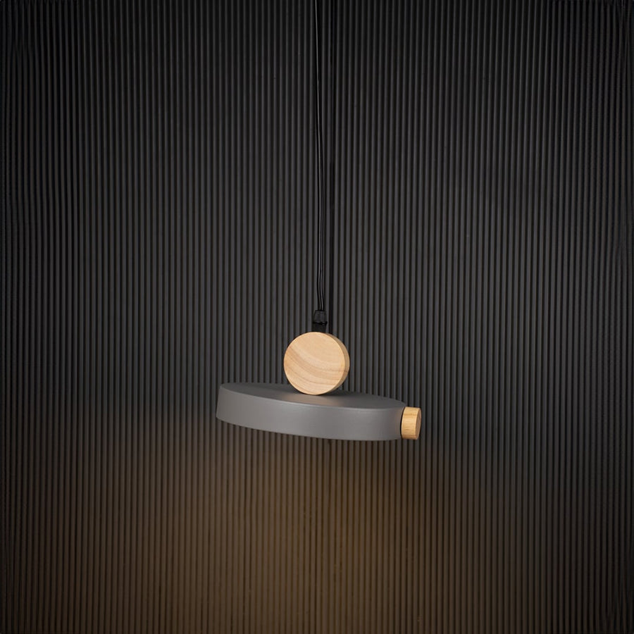 Wood and metal pendant light glowing on black background with circular design and modern minimalist style.