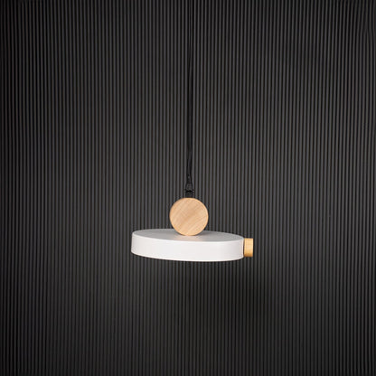 Modern pendant light with flat round shade and wood detail bulb off on black background for stylish home interiors.