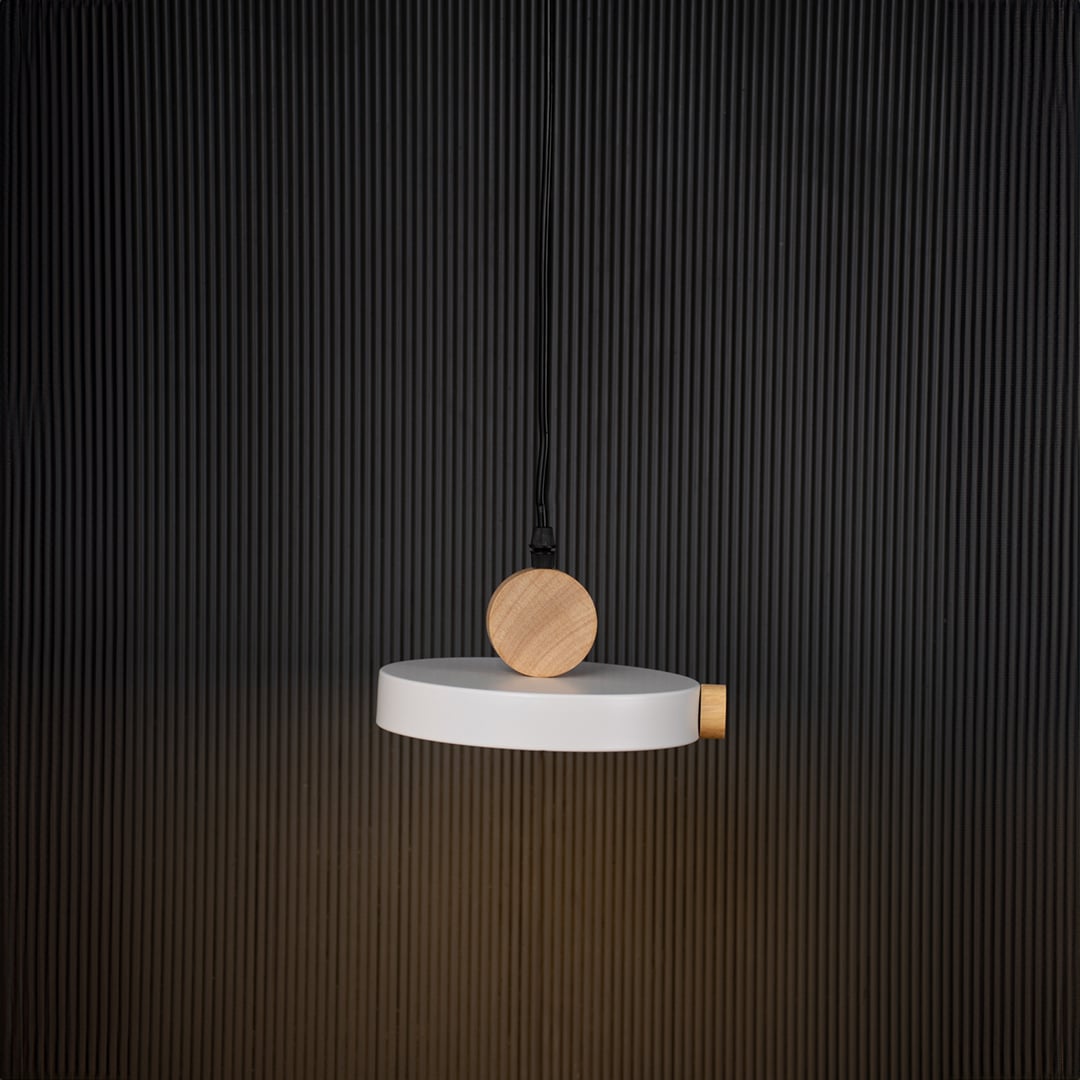 Modern pendant light with flat round shade and natural wood design glowing on black background for stylish interiors.