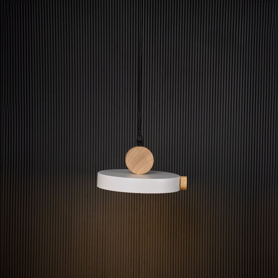 Modern pendant light with flat round shade and natural wood design glowing on black background for stylish interiors.