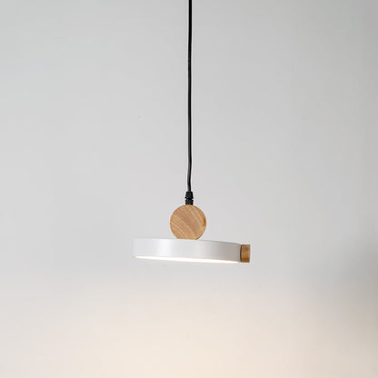 Pendant light glowing on white background with round flat metal shade and natural wood accents for modern interiors.