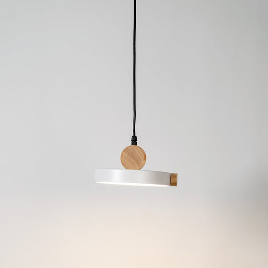 Pendant light glowing on white background with round flat metal shade and natural wood accents for modern interiors.