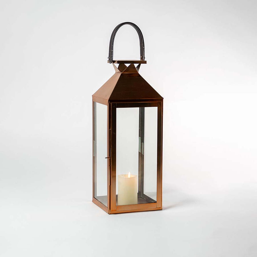 Lit bronze lantern against a white background showcasing its clean lines geometric roof and sleek metallic sheen.