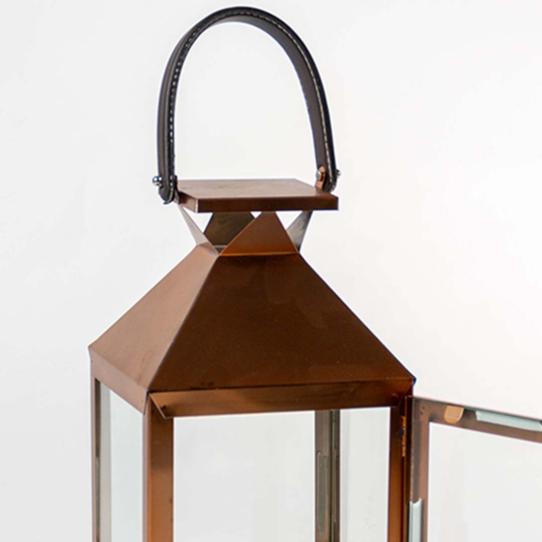 Detailed closeup of the bronze lantern showing smooth metal edges clear glass panels and a sturdy handle for both functionality and modern design aesthetics.