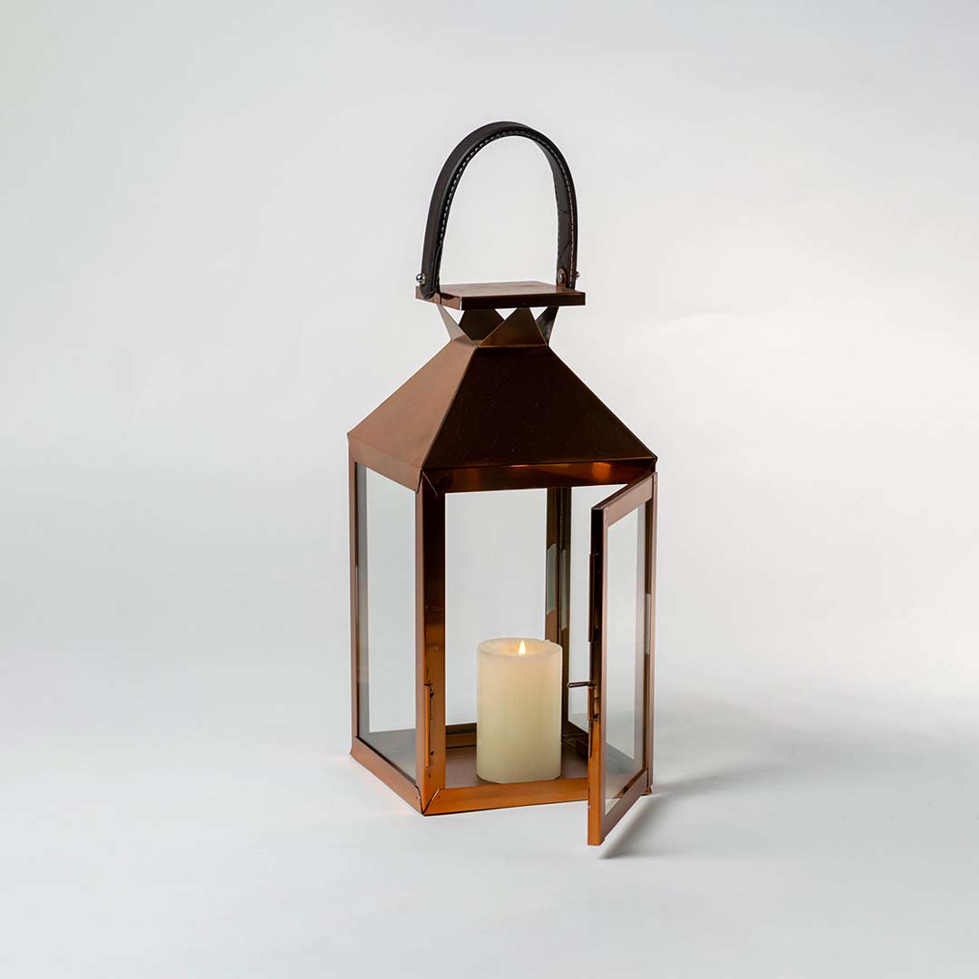 Copper metal lantern with clear glass panels and candle holder for farmhouse tabletop decor styling.