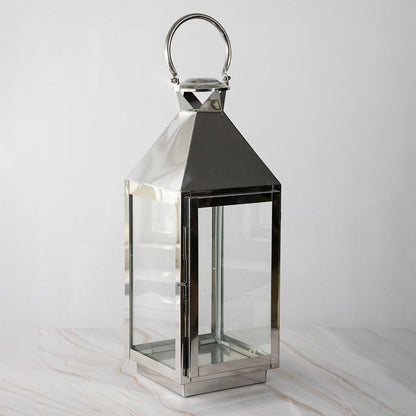 Tall stainless steel lantern turned off shown plain on white background highlighting polished finish.