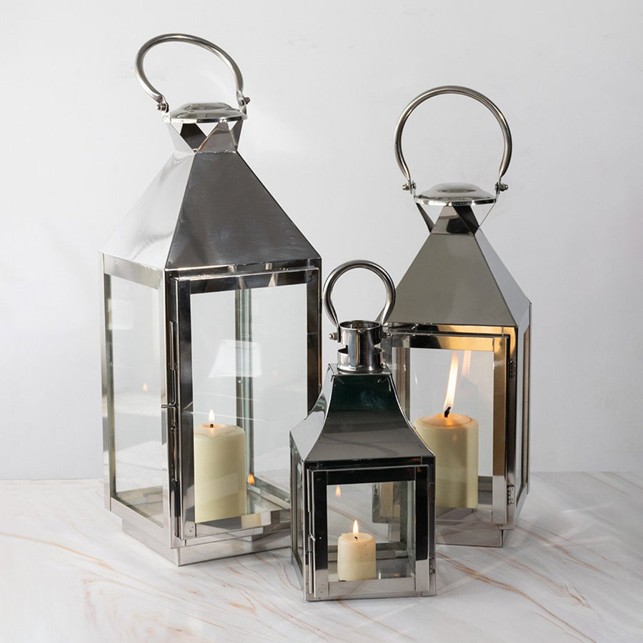 Black metal lantern candle holders with clear glass panels styled for modern dining table and home decor use.