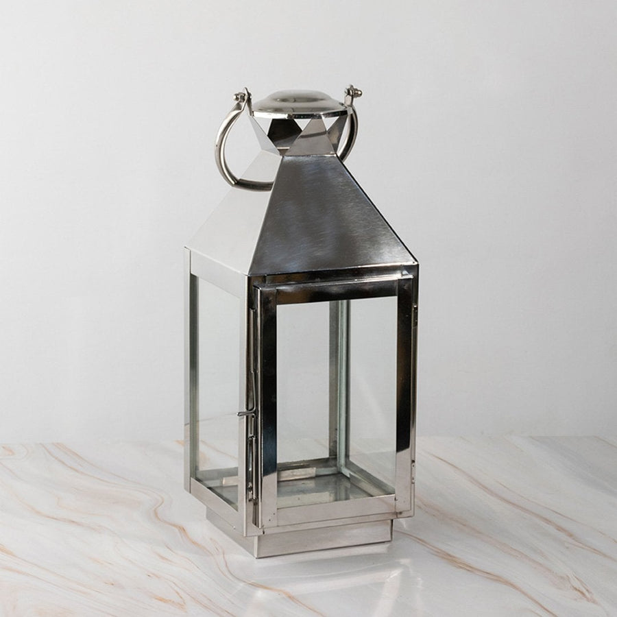 Stainless steel lantern turned off displayed plain on white background highlighting polished finish.