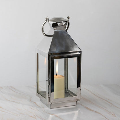 Stainless steel lantern lit displayed plain on white background highlighting polished finish.