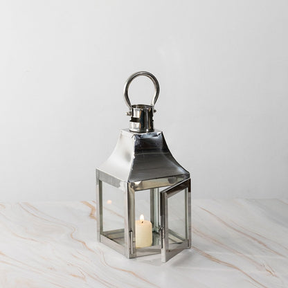 Stainless steel lantern with candle lit displayed on white background for modern home and garden decor.