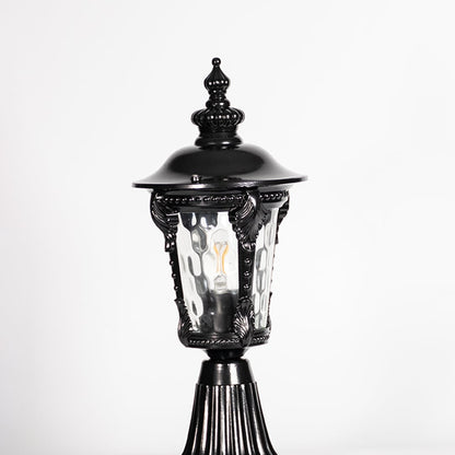 Closeup of black pillar light showing ornate frame design and patterned clear glass for stylish vintage outdoor lighting.