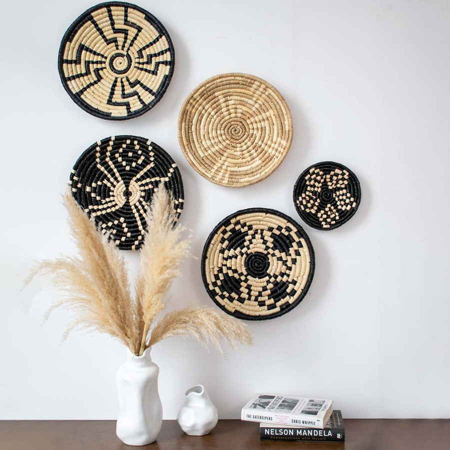 Handcrafted woven wall basket displayed above console table with vases and books – bohemian home wall decor accent.
