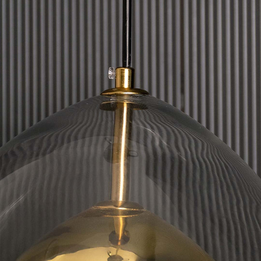Closeup view of the golden glass pendant light highlighting the smooth transparent shade and reflective gold interior with clear detailing and craftsmanship.
