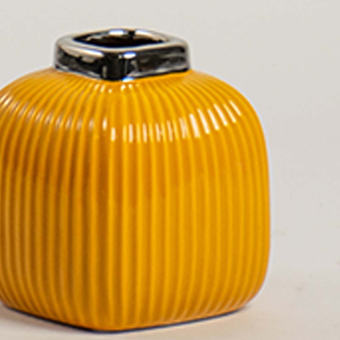 Closeup of yellow ceramic ribbed vase showing glossy top detail and smooth textured finish for a stylish decor accent.