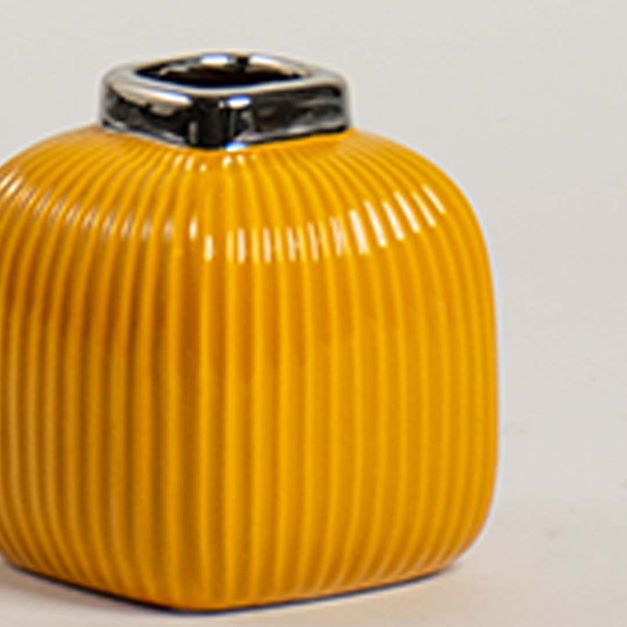 Closeup of yellow ceramic ribbed vase showing glossy top detail and smooth textured finish for a stylish decor accent.