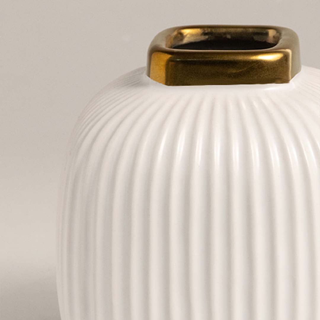 Closeup view of the ribbed ceramic vase showing detailed vertical texture and metallic gold rim finish.