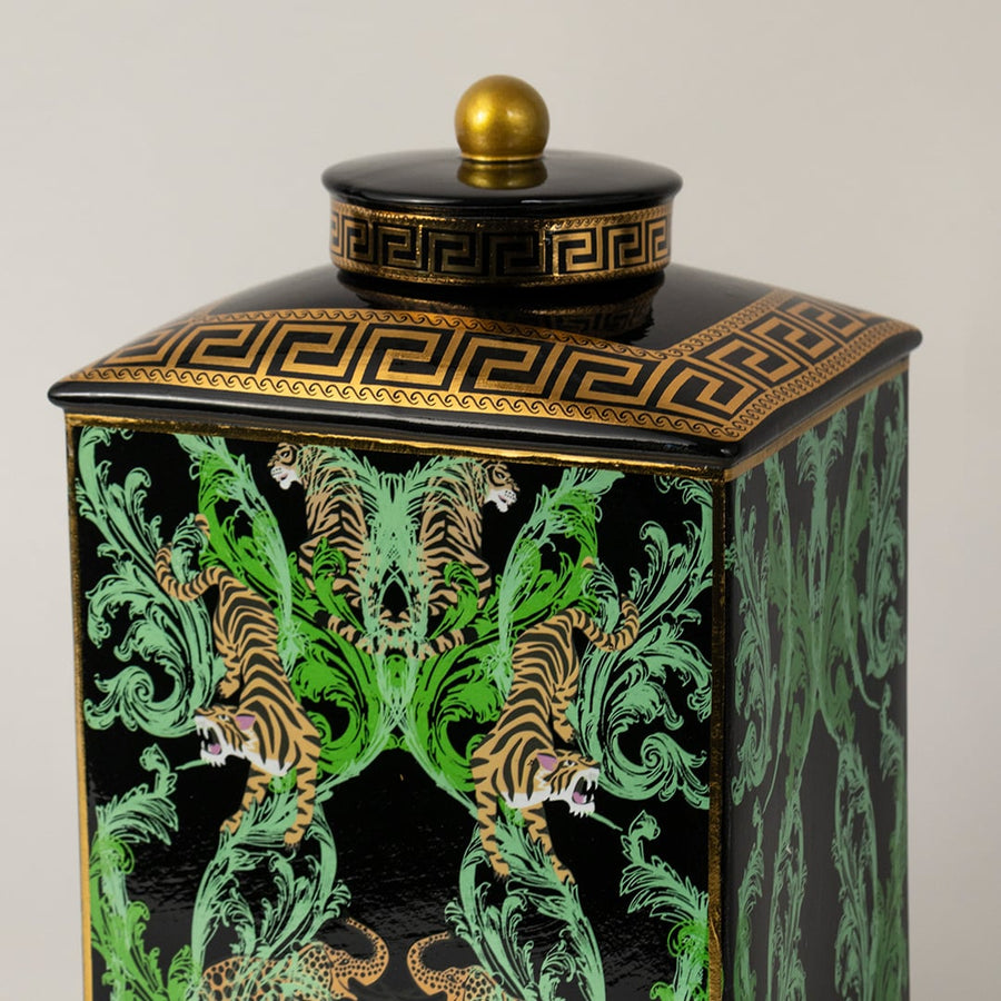 Closeup of black ceramic jar showing artistic tiger details and glossy gold-trimmed lid.