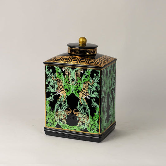 Black ceramic jar against white background emphasizing ornate gold detailing and glossy enamel finish.