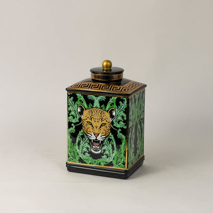 Side angle view of black ceramic jar showing elegant golden top and bold leopard-themed artwork.