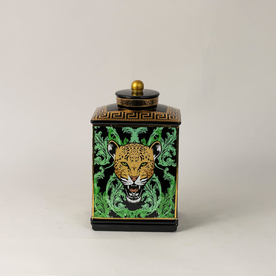 Black ceramic jar against white backdrop emphasizing glossy finish and vivid gold-green detailing.