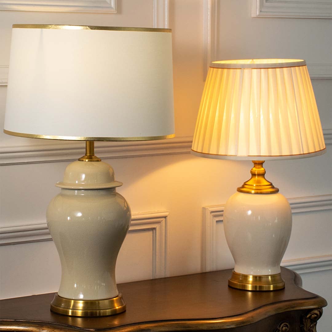 Jarro ceramic table lamps turned on grouped with white and pleated shades featuring gold bases perfect for luxury home decoration.