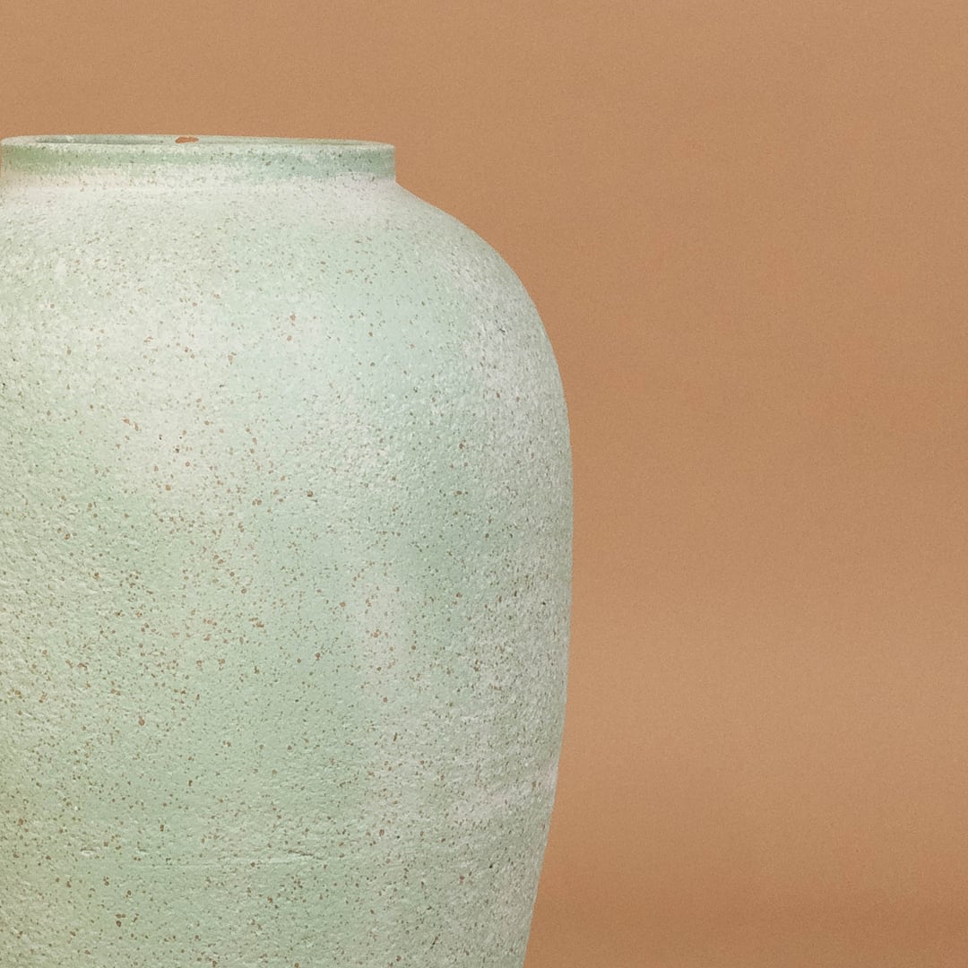 Closeup of mint green ceramic vase showing textured handcrafted finish and smooth form ideal for modern living room or hallway styling.