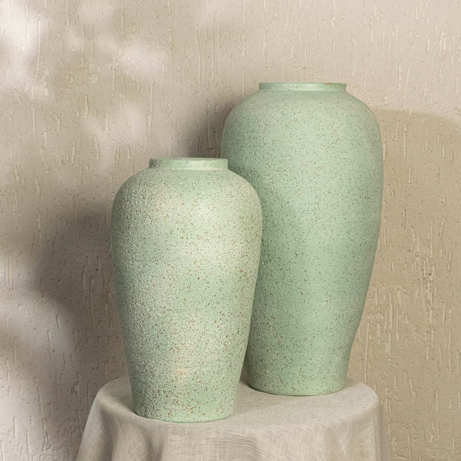 Mint green textured ceramic vase adding modern decor charm to living room spaces with tall elegant design perfect for styling corners.