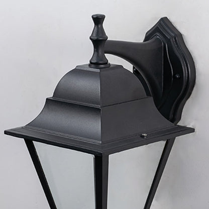 Closeup of outdoor black wall lantern showing detailed craftsmanship  smooth matte finish  and transparent glass panels.