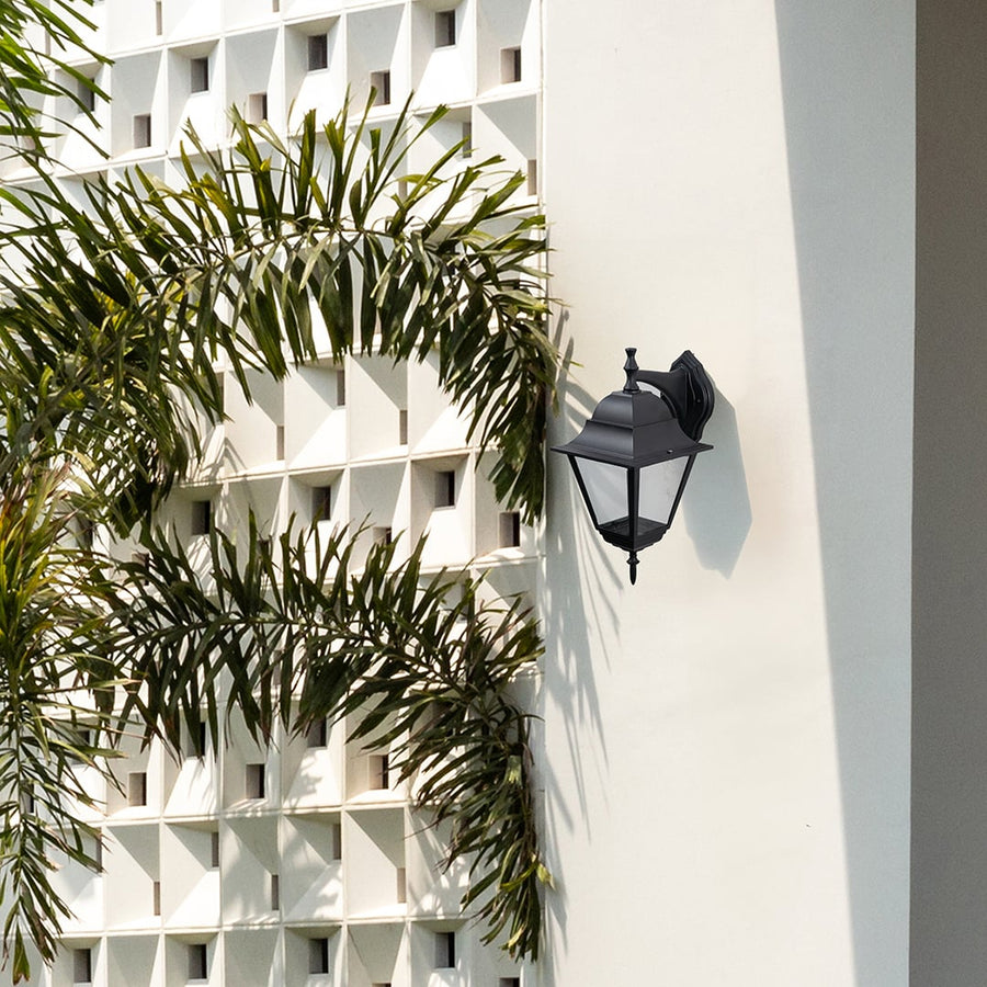 Elegant black outdoor wall lantern enhancing modern exteriors with its vintage charm and soft ambient lighting effect.