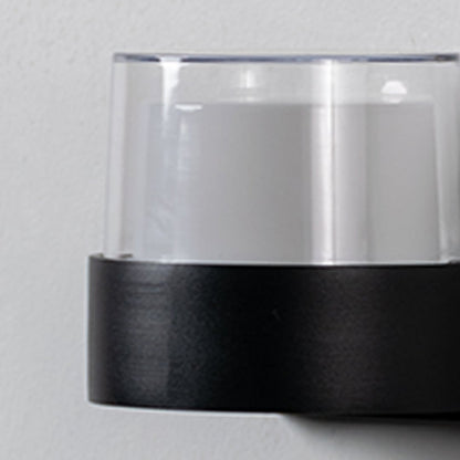 Closeup of modern wall light highlighting matte black base with clear glass shade designed for stylish and balanced lighting.