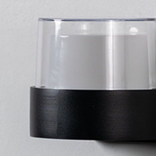 Closeup of modern wall light highlighting matte black base with clear glass shade designed for stylish and balanced lighting.