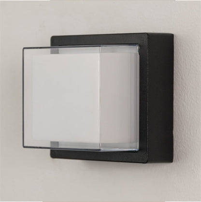 Black metal wall light on white background with frosted glass shade for modern minimalist exterior decor.