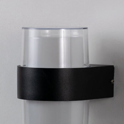 Closeup view of cylindrical wall light highlighting clear glass shade with matte black band for modern architectural aesthetics.