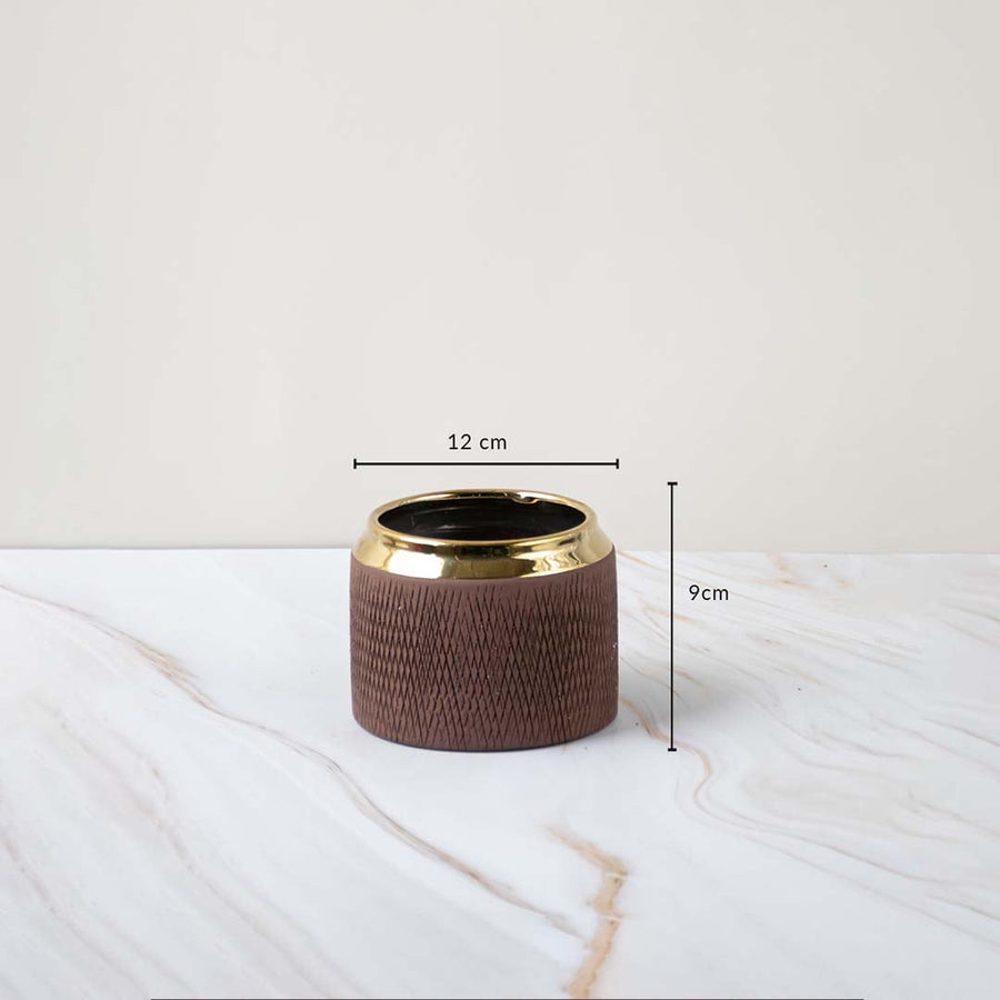 A brown textured vase with a gold rim shown with measurements of 12 cm width and 9 cm height clearly displaying its compact decorative size.