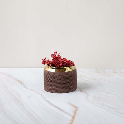 A low brown vase with a gold rim placed on a soft marble background showing a refined stylish look perfect for enhancing modern interiors.