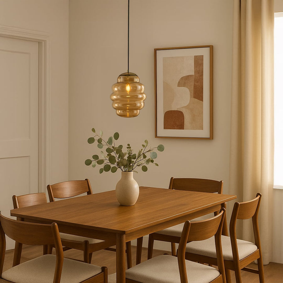 Amber ripple pendant light hanging above wooden dining table adding warm glow and modern elegance to cozy interiors.