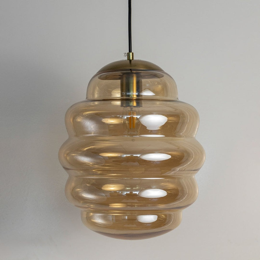 Amber ripple pendant lights softly illuminated sgainst white background adding elegant warm lighting to contemporary home interiors.